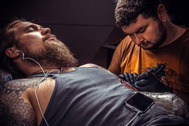 Ana bir dövme dövme salonu. içinde yapma işlemi gösteren / profesyonel dövmeci tattoo studio poz.