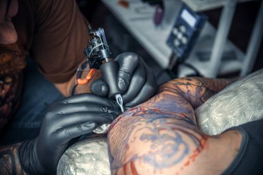 Profesyonel tattooer bir dövme dövme salonu. içinde yapma işlemi gösteren / profesyonel dövmeci salonda çalışıyor.