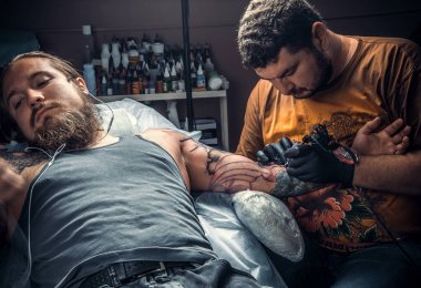 İş yerinizde dövme salonu. dövme uzman / profesyonel dövmeci dövme salonda yapıyor.