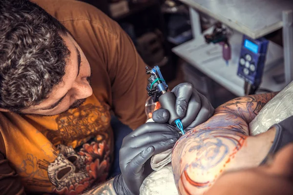 Artista de tatuagem profissional trabalhando tatuagem no estúdio de tatuagem — Fotografia de Stock