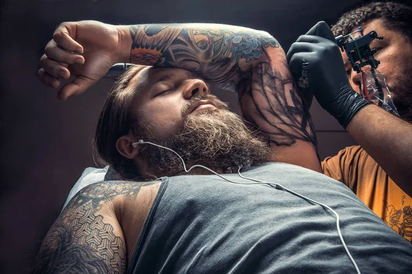 Tattoo specialist showing process of making a tattoo in tattoo studio — Stock Photo, Image