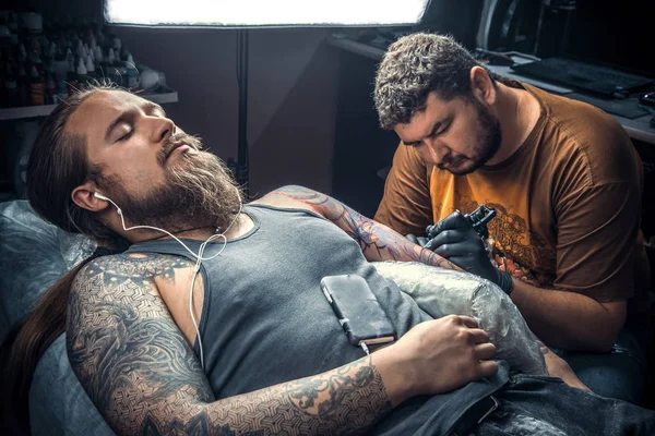 Tattoo master create tattoo in tattoo parlor