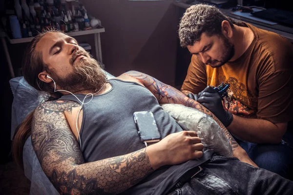 Professional tattooer making a tattoo in tattoo parlor — Stock Photo, Image