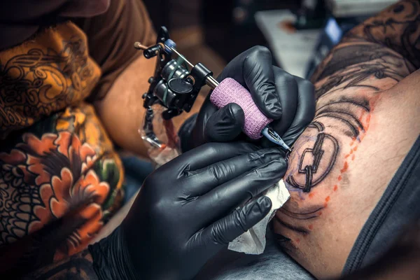 Artista de tatuagem profissional fazendo tatuagem no salão de tatuagem — Fotografia de Stock