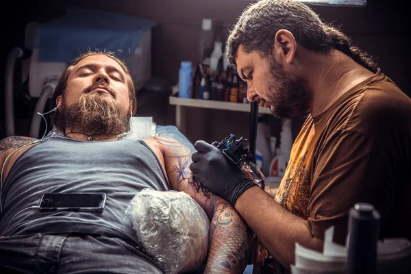 Artista de tatuagem profissional fazendo uma tatuagem no salão de tatuagem — Fotografia de Stock