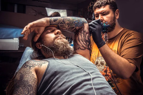 Professional tattoo artist works in tattoo studio — Stock Photo, Image