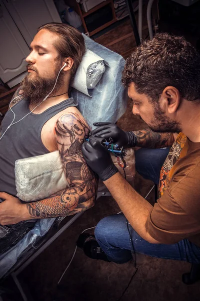 Tattooist makes tattoo in studio — Stock Photo, Image