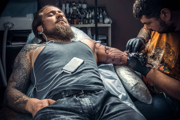 Professional tattoo artist makes tattoo pictures in tattoo studio — Stock Photo, Image