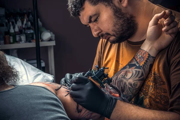 Tattooer posing in tattoo parlor