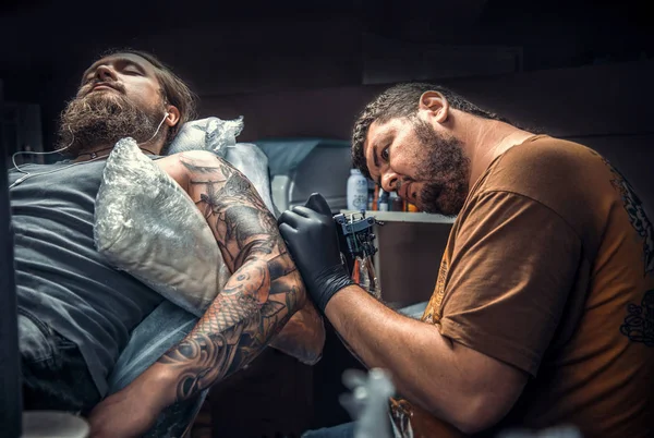 Tatuagem faz imagens de tatuagem em sala de tatuagem — Fotografia de Stock