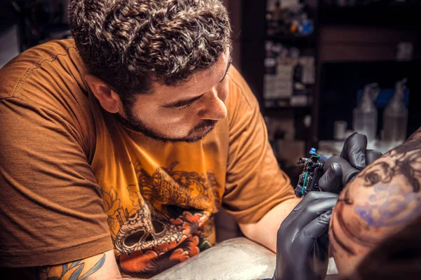 Tatuagem profissional faz tatuagem no salão de tatuagem — Fotografia de Stock