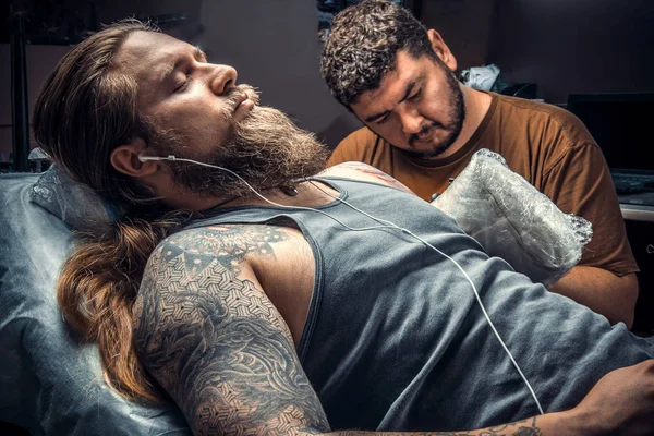 Tattoo artist create tattoo in salon./Professional tattoo artist makes tattoo pictures in tattoo studio.