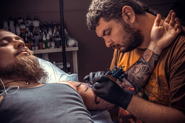 Tattooist posing in tattoo studio./Professional tattooist create tattoo in tattoo parlor.