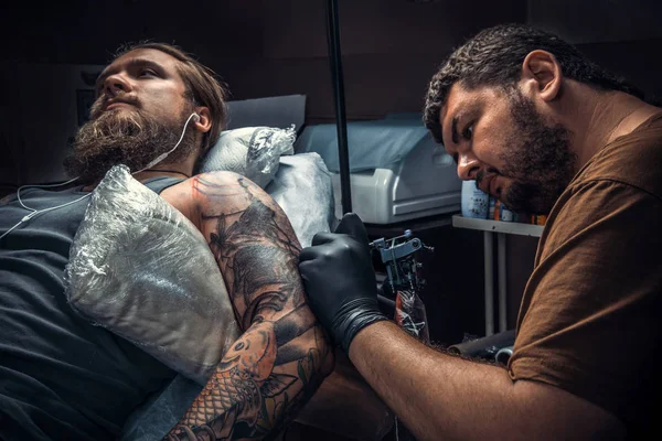 Tattoo artist doing tattoo in studio — Stock Photo, Image