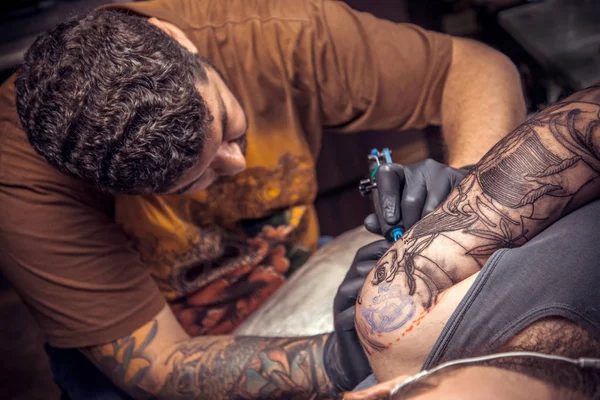 Профессиональный татуировщик на работе в тату-студии — стоковое фото