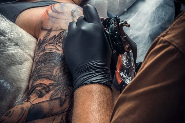 Artista de tatuagem profissional fazendo uma tatuagem no estúdio de tatuagem — Fotografia de Stock