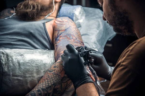 Tattoo master create tattoo in tattoo parlor — Stock Photo, Image