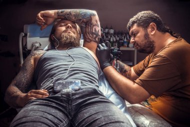 Dövmeci dövme dövme salonu. içinde yapma işlemi gösteren / profesyonel tattooer çalışma dövme tattoo studio.