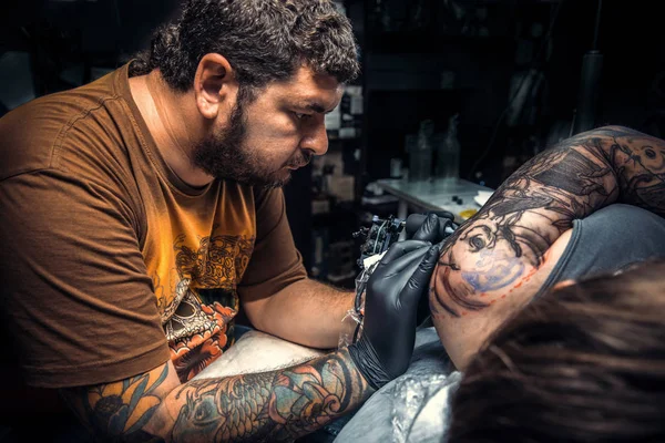 Tattooer create tattoo in tattoo studio