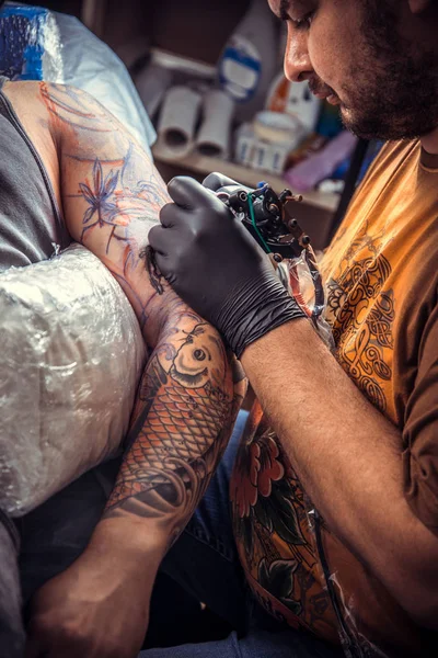 Tatuagem profissional fazendo uma tatuagem em estúdio — Fotografia de Stock