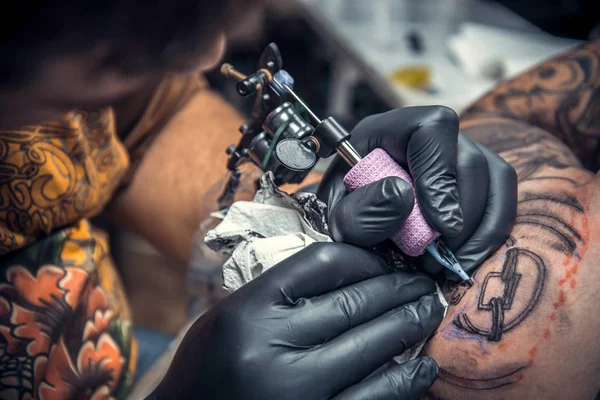 Tattooer making a tattoo in tattoo studio