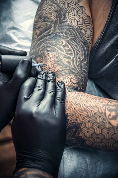 Especialista em tatuagem cria tatuagem no estúdio de tatuagem — Fotografia de Stock