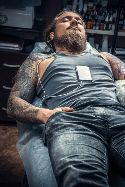 Professional tattooist works in studio