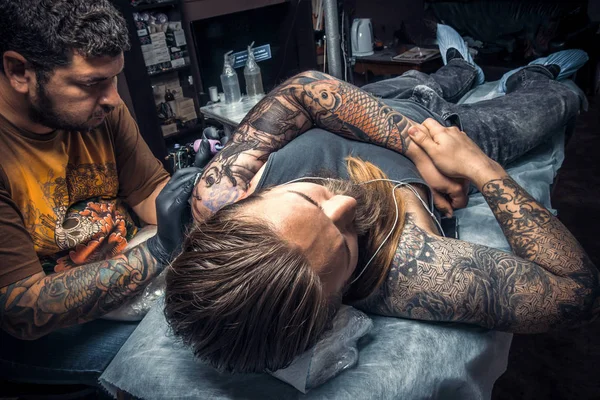 Tattooer makes tattoo pictures in tattoo studio