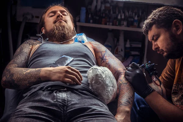 Artista profesional del tatuaje trabaja en salón de tatuaje —  Fotos de Stock