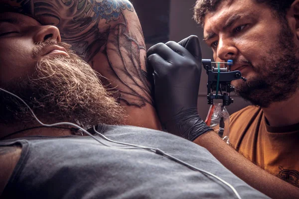 Mestre faz tatuagem legal no estúdio — Fotografia de Stock