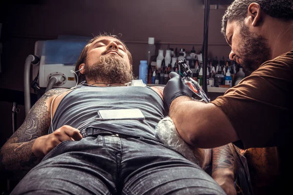 Tattooer робить зображення татуювання в тату-салон — стокове фото
