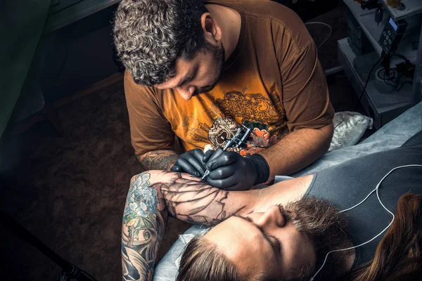 Tattoo artist works in studio — Stock Photo, Image