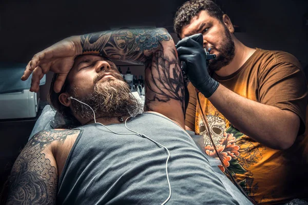 Профессиональный татуировщик позирует в студии — стоковое фото