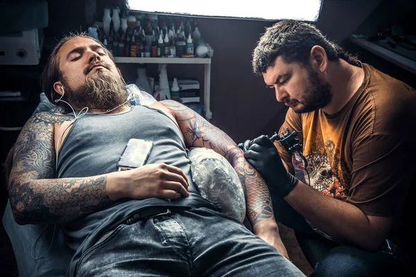 Tattoo specialist posing in tattoo parlor