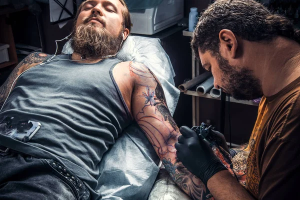 Tattoo artist works in studio