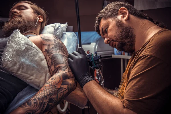 Tattooer create tattoo in tattoo parlor — Stock Photo, Image