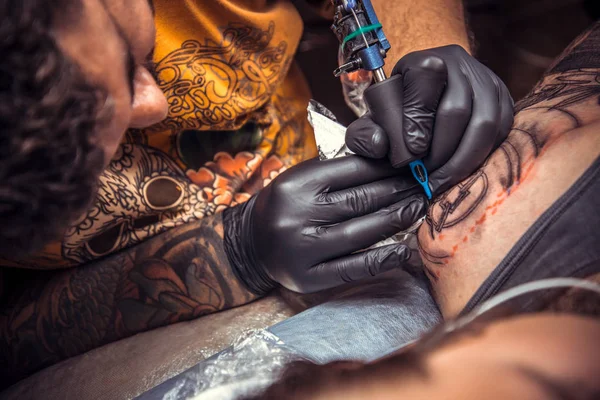 Mestre trabalhando tatuagem em estúdio — Fotografia de Stock