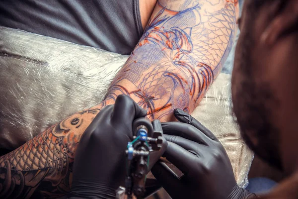 Professional tattooist at work in studio — Stock Photo, Image