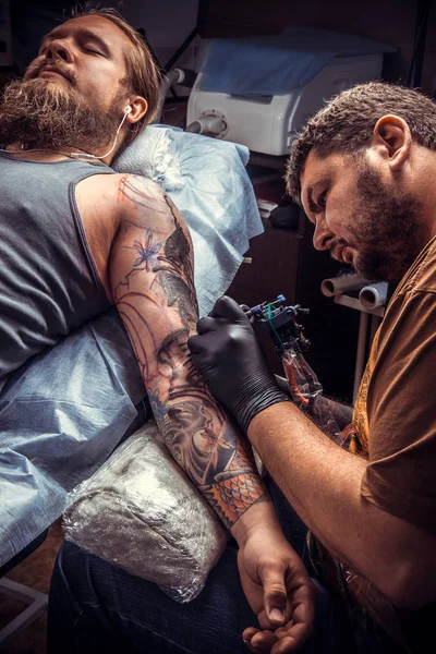 Tattoo master at work in tattoo parlor — Stock Photo, Image