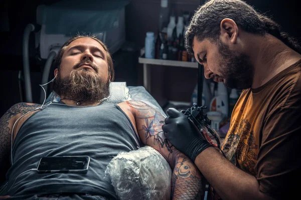 Tattooer visar processen att göra en tatuering i tatueringsstudio — Stockfoto