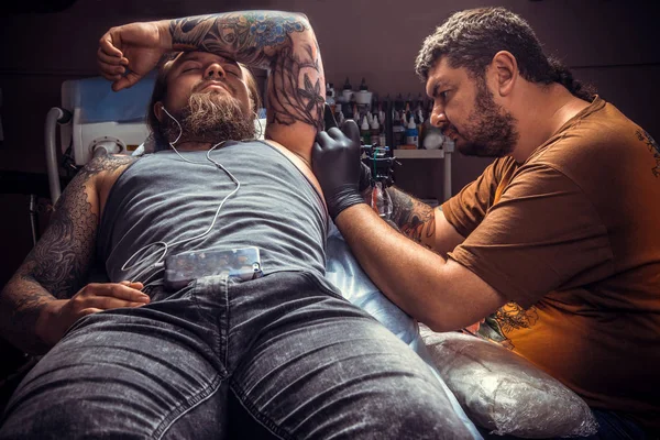 Професійний художник татуювання працює татуювання в татуювальному салоні — стокове фото