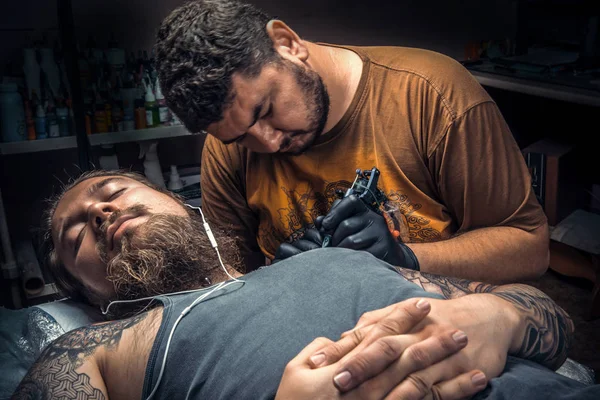 Tatuagem profissional fazendo uma tatuagem em estúdio — Fotografia de Stock