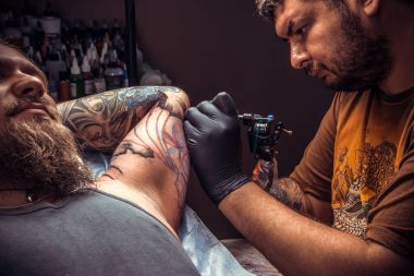 Profesyonel tattooer serin dövme dövme salonunda yapar.