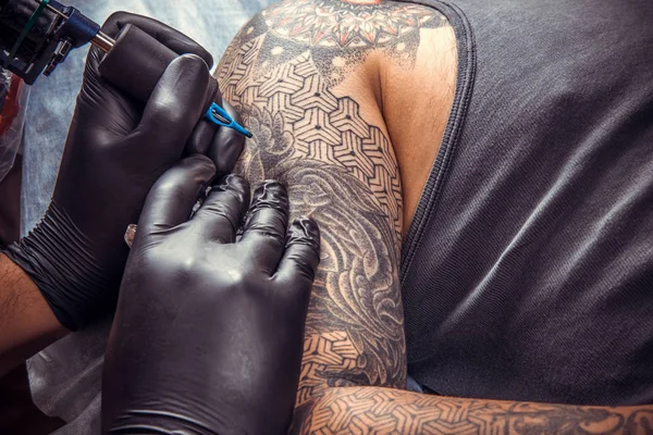 Tattoo specialist makes tattoo pictures in tattoo parlor — Stock Photo, Image