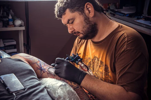 Maestro del tatuaje hace tatuaje en estudio de tatuaje — Foto de Stock