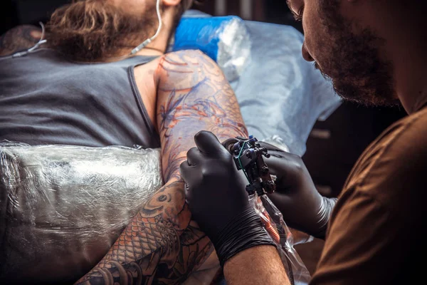 Maestro del tatuaje hace tatuaje en estudio de tatuaje — Foto de Stock