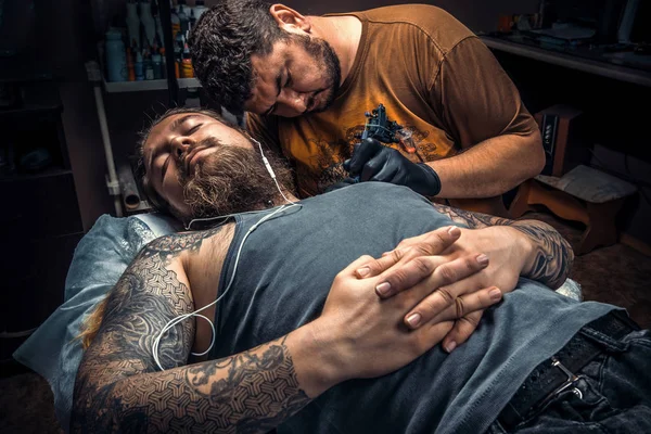 Tattoo specialist at work in tattoo parlor