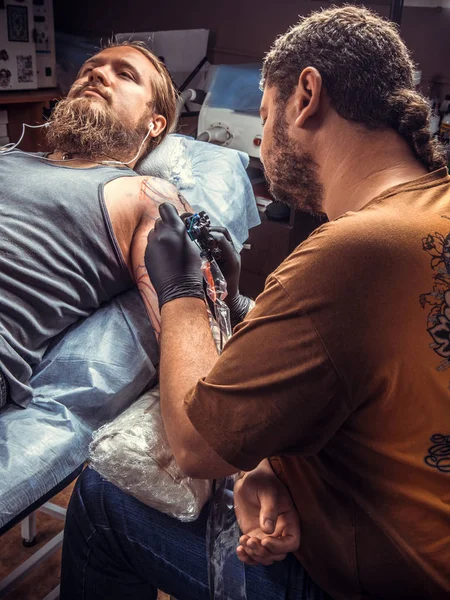 Профессиональный татуировщик, позирующий в тату-салоне — стоковое фото