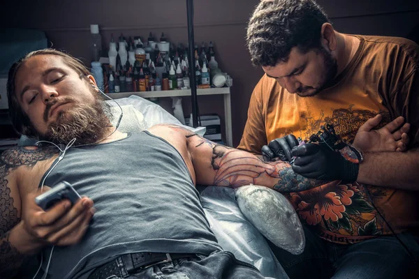 Tatueraren att göra en tatuering i studio — Stockfoto