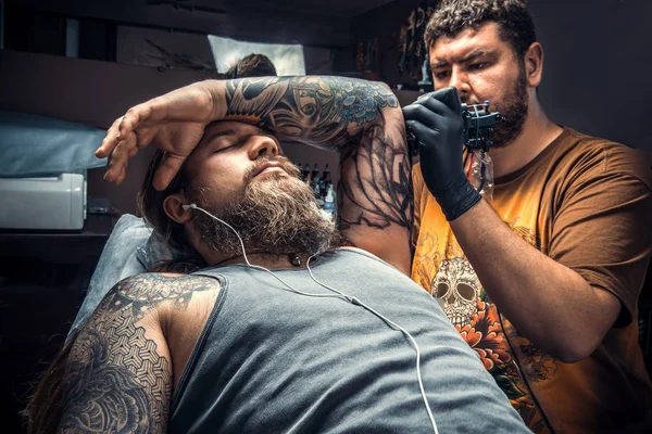 Tattooer create tattoo in tattoo parlor — Stock Photo, Image